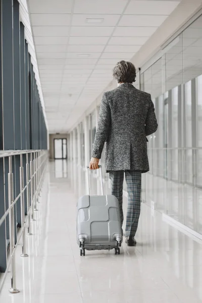 Senior Geschäftsmann mit Reisekoffer im Flughafen — Stockfoto