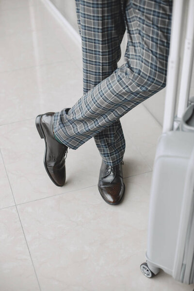 Senior businessman with travel suitcase in airport