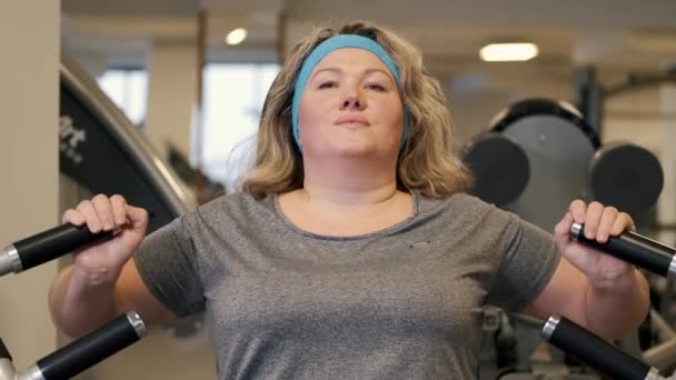 Mujer haciendo ejercicios de fitness en la máquina de prensa de pecho en el gimnasio — Vídeo de stock