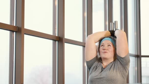 Overweight mulher formação com halteres no ginásio — Vídeo de Stock