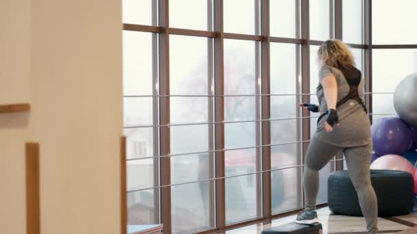 Mujer con exceso de entrenamiento con pesas en gimnasio con stepper — Vídeo de stock