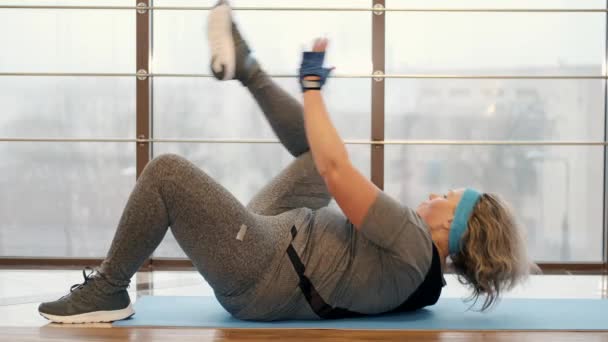Dikke vrouw doet crunches in het fitnesscentrum — Stockvideo