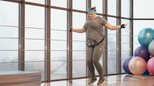 Mujer con exceso de ejercicio de peso incansablemente en un gimnasio — Vídeo de stock