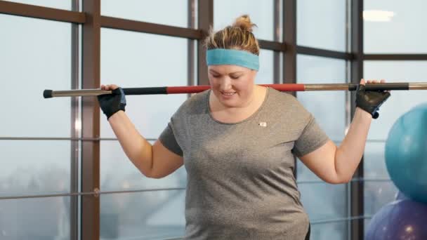 Mujer con exceso de ejercicio de peso incansablemente en un gimnasio — Vídeo de stock