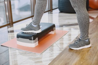 Yetişkin şişman kadın spor salonunda jimnastik yapıyor.