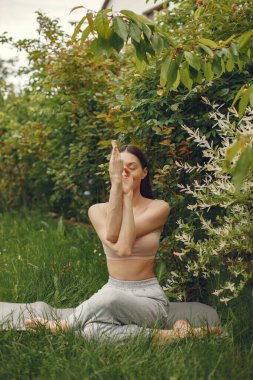 Parkta yoga yapan bir kadın.
