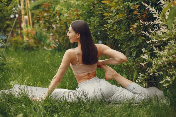 Женщина практикует продвинутую йогу в парке — стоковое фото