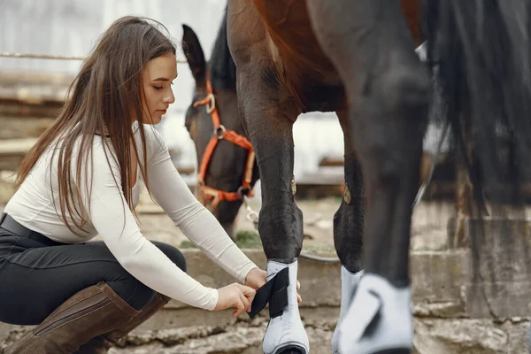 Elegant flicka på en gård med en häst — Stockfoto