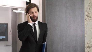 Girişimci ofiste cep telefonuyla konuşuyor