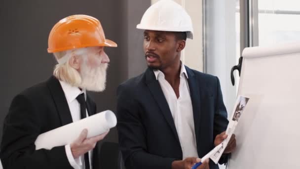 Architekt a inženýr se dívá na scketch plán v kanceláři a diskutuje o projektu — Stock video