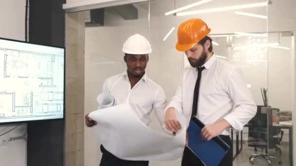 Arsitek dan insinyur melihat scketch blueprint di kantor dan mendiskusikan proyek — Stok Video