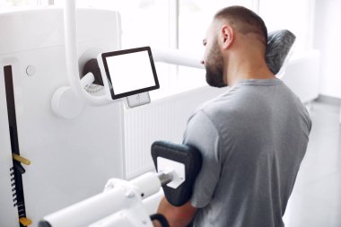 Sakallı adam fizyoterapi kliniğinde yaralandıktan sonra rehabilitasyon görüyor.