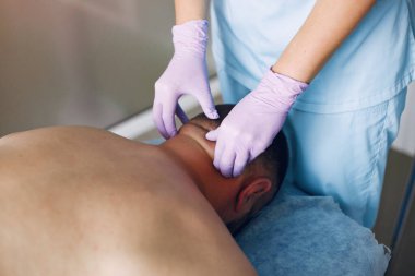 Doktor hastahanedeki adama masaj yapıyor.