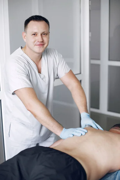 The doctor massages the man in the hospital — Stock Photo, Image