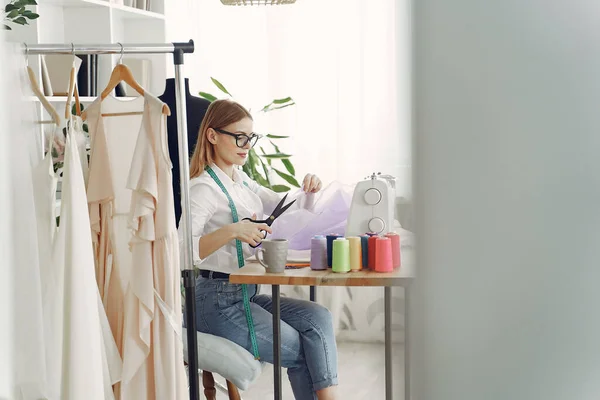 Frau sitzt im Atelier und näht Stoff — Stockfoto