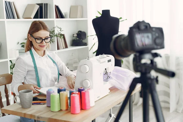 Žena sedí ve studiu a šít látku — Stock fotografie