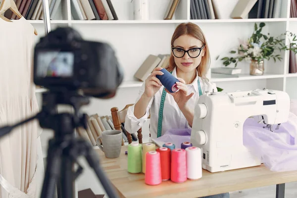 Žena sedí ve studiu a šít látku — Stock fotografie