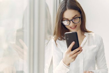 Ofiste elinde telefon olan bir kız.