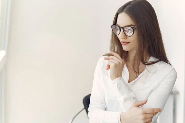 Zakenvrouw in een wit shirt zittend op kantoor — Stockfoto