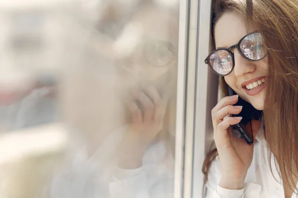 Dívka stojící v kanceláři s telefonem — Stock fotografie