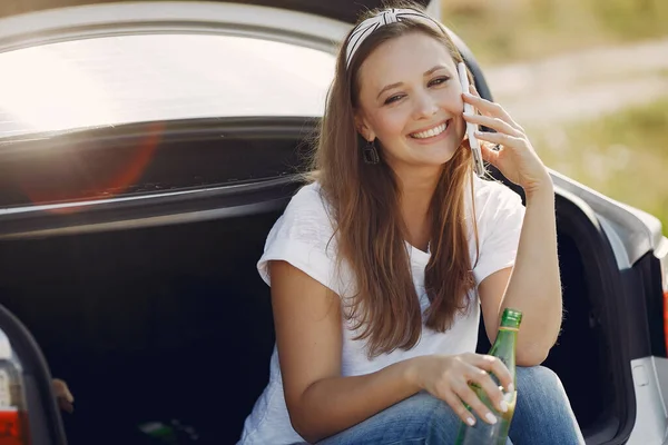 Elegante donna seduta in un tronco con acqua — Foto Stock