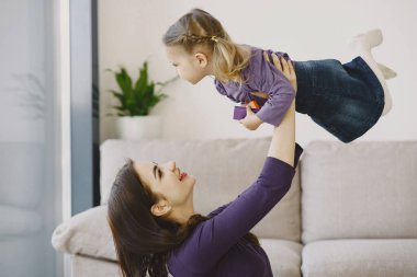 Neşeli anne küçük kızıyla gülüyor.