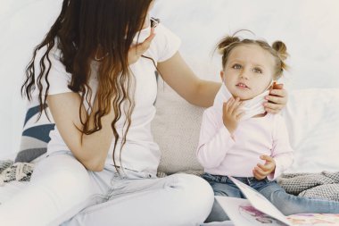 Tıbbi maskeli anne ve bebek evde.