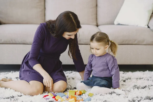 Fröhliche Mutter spielt lachend mit kleiner Tochter — Stockfoto