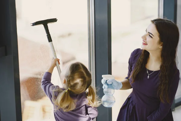 Dcera a matka čistí okno společně — Stock fotografie