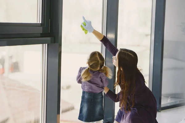 Dcera a matka čistí okno společně — Stock fotografie