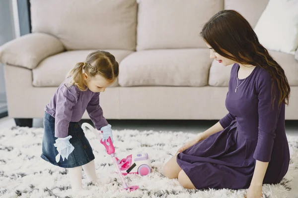 Маленька дівчинка прибирає підлогу з іграшковим пилососом — стокове фото
