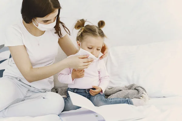 Mother and baby at home with medical masks