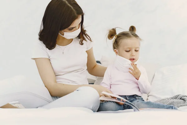 Mutter und Baby zu Hause mit medizinischen Masken — Stockfoto