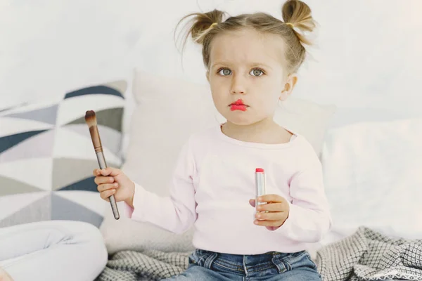 Menina bonita com cosméticos de maquiagem em casa — Fotografia de Stock