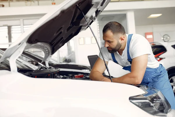 Un bel homme en uniforme bleu vérifie la voiture — Photo