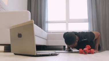 Kararlı erkek sporcu evde egzersiz yapıyor.