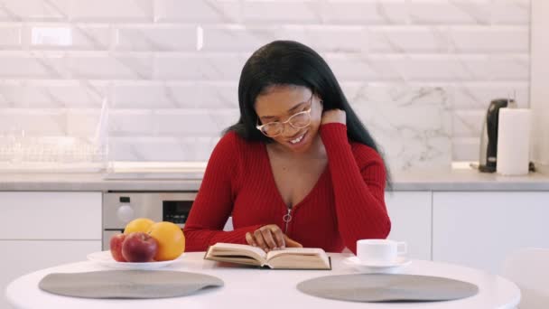 Menina afro-americana bebendo café e estudando em casa na cozinha — Vídeo de Stock