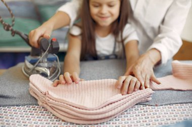 Anne ve küçük kızı fabrikadaki kumaşı ütülüyorlar.