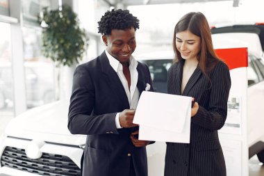 Yakışıklı ve zarif bir siyah adam bir araba salonunda.