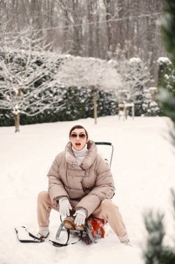 Kış ormanında rahat bir kadının açık havada çekilmiş fotoğrafı.