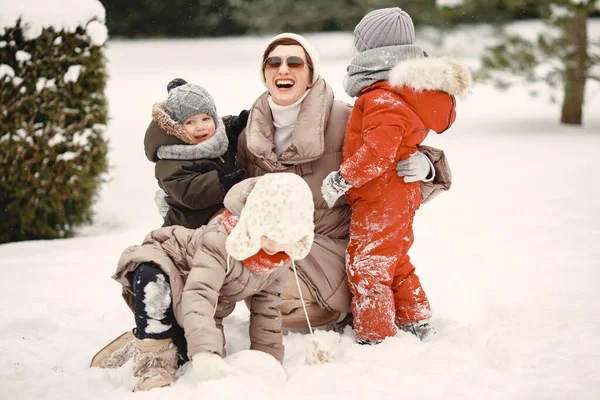 Madre e bambini in abiti invernali giocano nel cortile — Foto Stock