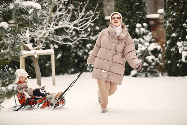 Mutter und Kind in Winterkleidung spielen auf dem Hof — Stockfoto