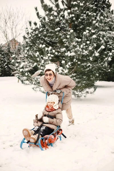 Mère et enfant en vêtements d'hiver jouent à la cour — Photo
