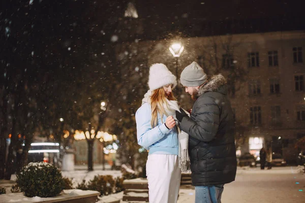 Młoda para na zewnątrz w nocy ulicy w czasie Bożego Narodzenia — Zdjęcie stockowe