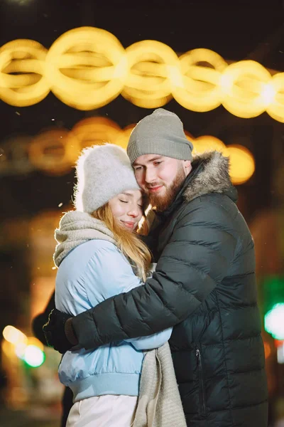 Young couple outdoor in night street at christmas time