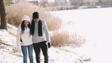 Şık bir çift kışın kırsalda yürüyor ve eğleniyor.