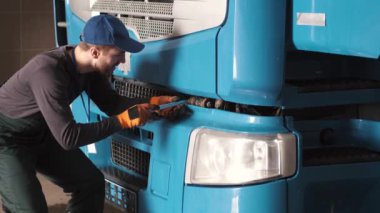 Profesyonel araba tamircisi araba garajındaki kamyon motorunu kontrol ediyor.