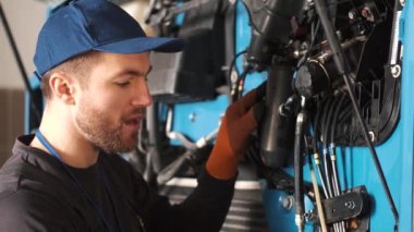 Profesyonel araba tamircisi araba garajındaki kamyon motorunu kontrol ediyor.