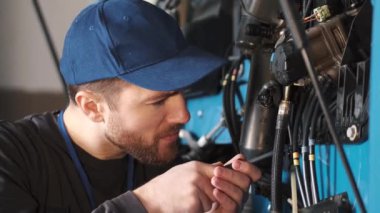 Profesyonel araba tamircisi araba garajındaki kamyon motorunu kontrol ediyor.