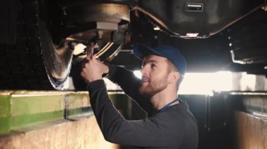 Otomatik tamirci alttaki kamyon süspansiyonunu tamir etti